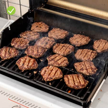 The Weber Spirit E-325 gas grill cooking burgers evenly.